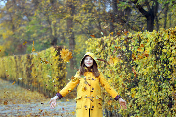 autumn leaves fall around the girl in the park