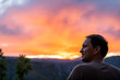 © Kristina Blokhin - Aspen, Colorado rocky mountains colorful sunset in blurry background with back of young man looking at view at twilight
