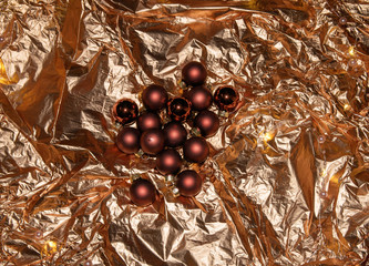 New Year's toys in the form of balls lie on a gold festive foil