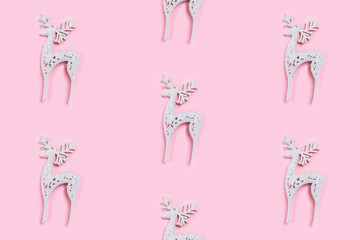 Wall Mural - Pattern made of white christmas deer decoration on pastel pink background.