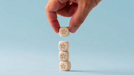 Wall Mural - male hand stacking five wooden dices with star shape on them