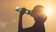 Woman Drinking Bottle Of Water Outdoors