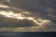 © Nigel Matthews - Shafts of Light breaking through dark dramatic clouds over the ocean