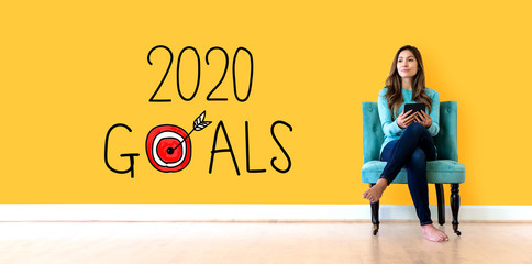 Wall Mural - 2020 goals concept with young woman holding a tablet computer