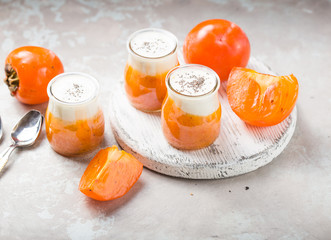 Chia pudding with persimmon. Autumn or winter dessert. light gray background. Healthy vegan, vegetarian breakfast table.