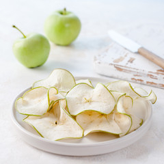 Healthy eating. Аpple chips and two green apples on the table.