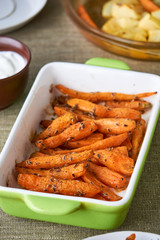 Wall Mural - Baked carrots with dill seeds in a ceramic form