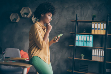 Wall Mural - Profile side photo of concentrated afro american girl entrepreneur freelancer use smartphone think thoughts decide choose start-up career solution in office loft