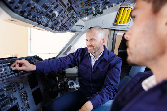 young aviation technician in the cockpit with his trainer