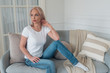 © semenenkostas - Slim beautiful girl posing on the couch in white t-shirt and blue jeans