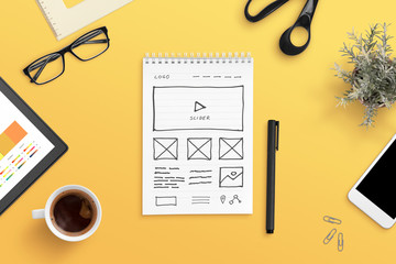 Fototapete - Web design studio concept with web site layout sketch on paper. Orange work desk, flat lay, top view composition.