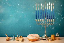 Concept Of Of Jewish Religious Holiday Hanukkah With Glittering Raditional Chandelier Menorah, Spinning Top Toys (dreidel), A Doughnut And Chocolate Coins