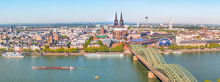 Aerial Panorama Of The Hohenzollern Bridge Over Rhine River On A Sunny Day. Beautiful Cityscape Of Cologne, Germany  With Cathedral And Great St. Martin Church In The Background