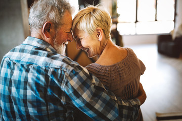 Poster - Happy senior couple in love hugging and bonding with true emotions at home