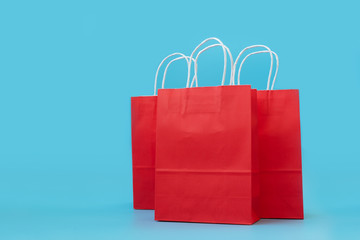  Red paper bags on blue background. Christmas and New Year holidays or sale concept. Copy space. Mock-up
