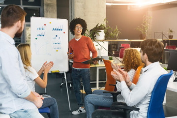 Wall Mural - Inspired black guy explaining new idea to colleagues