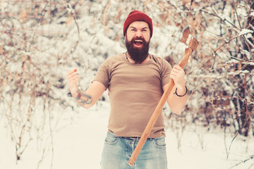 Excited bearded man screaming yes in winter forest. Brutal lumberjack holds axe in snowy woodland. Brutal man walk in winter