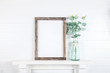 Mockup of a rough wooden frame on a white wall background in the interior