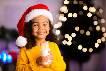 Cheerful african girl enjoying warm tasty milk at home