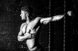 © Srdjan - Young sweaty muscular strong fit man stretching his arm and chest muscles after heavy and hard cross workout training in the gym real people black and white