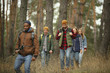 © master1305 - Group of friends on a camping or hiking trip in autumn day. Men and women with touristic backpacks going throught the forest, talking, laughting. Leisure activity, friendship, weekend.