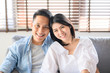 © interstid - Asian couple in love smiling relaxing on sofa at home