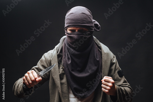 Cuadros en Lienzo criminal in a mask threatens with a knife the dark background