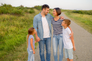 Wall Mural - Shot of a family of four enjoying a sunny day in the nature