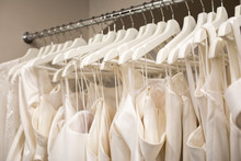 Wedding Dresses Hanging On A Hanger. Fashion Look. Interior Of Bridal Salon.