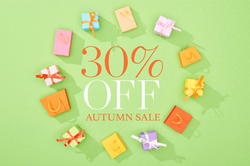 Canvas Print - round frame of decorative gift boxes and shopping bags on green background with 30 percent off autumn sale illustration