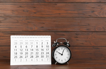 Canvas Print - Calendar and alarm clock on wooden table