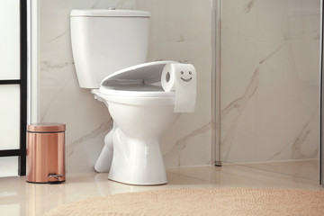 Wall Mural - Roll of paper with funny face on toilet bowl in bathroom