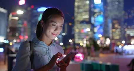 Wall Mural - Woman check on cellphone in city at night