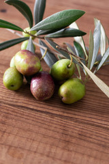 Wall Mural - natural olives with olive branches and rustic wooden background