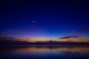 Wall Mural - The moon and first star on sky at the lake in the twilight after sunset.