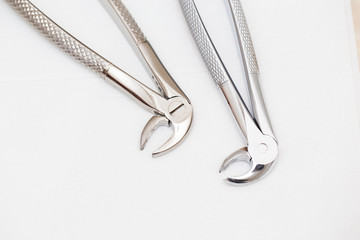 Dental forceps for removing teeth on a white isolated background.