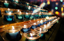 Candles In A Church, Cathedral Or Temple, In Blue Transparent Candlesticks. The Concept Of Mourning. We Remember, We Grieve. Selective Focus, Side View, Copy Space