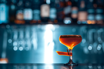 glass of fresh orange cocktail on blue background