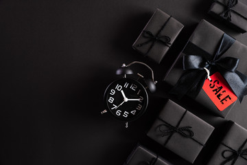 Wall Mural - Top view of Black Friday Sale text with black gift box with Alarm clock on white background. Shopping concept boxing day and black Friday composition.
