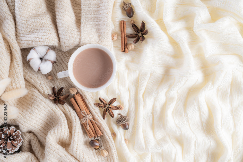 Autumn or winter composition. Coffee cup, cinnamon sticks, anise stars, beige sweater on cream color knitted blanket background. Flat lay top view copy space. - obrazy, fototapety, plakaty 