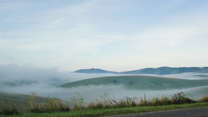 Sticker - Empty Road with landscape. Mist at asphalt. Fog at highway. Nature in countryside with green hills. Travel and journey. Route in summer. Freeway view with background. Horizon perspective. Outdoor.