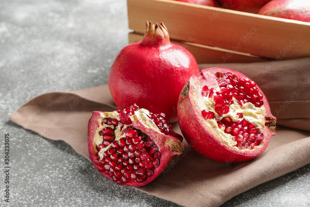 Ripe juicy pomegranates on grey background
