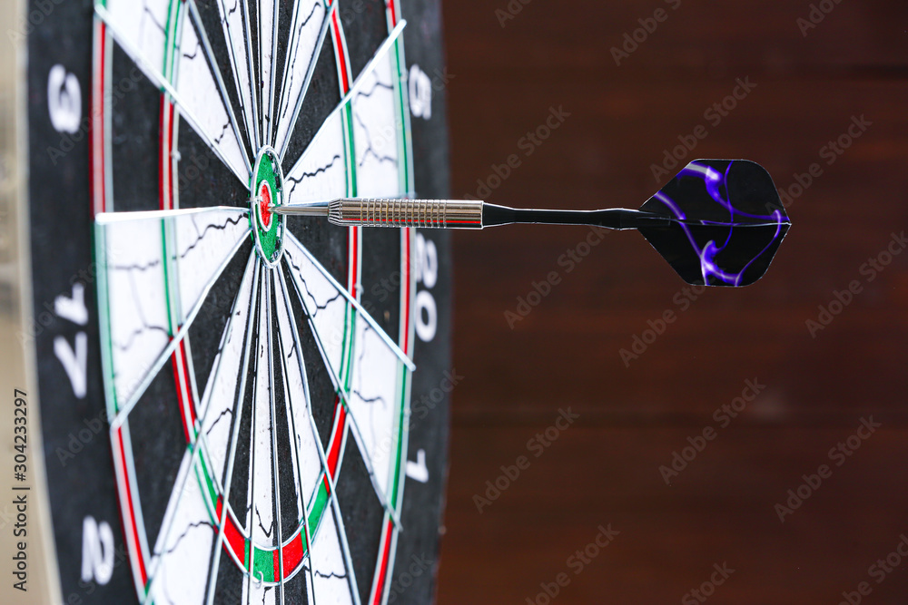 Dartboard with hit bullseye on dark background, closeup