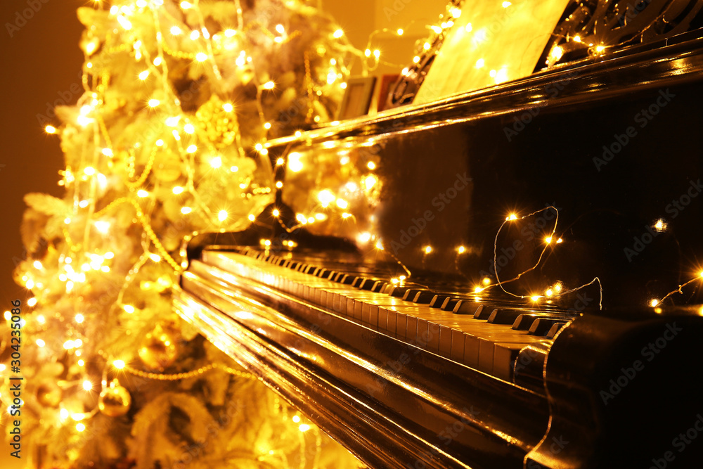 Piano with glowing Christmas garland, closeup