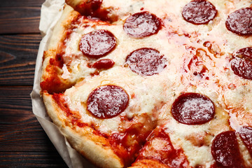 Hot delicious pepperoni pizza on wooden table, closeup