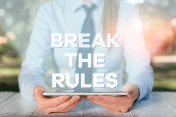 Handwriting text writing Break The Rules. Conceptual photo Make changes do everything different Rebellion Reform Female business person sitting by table and holding mobile phone