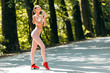 © speed300 - Full-length woman portrait in sportwear standing with a bottle of water in park outdoor
