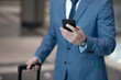 © zinkevych - Businessman wearing suit holding his smartphone while checking email