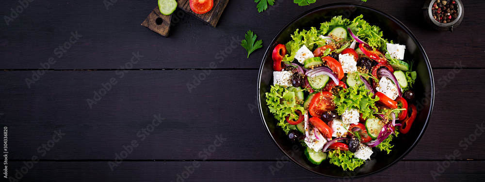 Healthy food. Greek salad with cucumber, tomato, sweet pepper, lettuce, red onion, feta cheese and olives.  Top view, banner - obrazy, fototapety, plakaty 