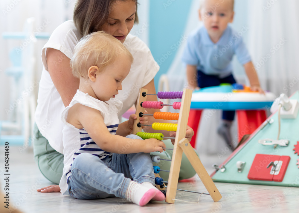 Kids playing on floor with developmental toys in kindergarten. Children ...